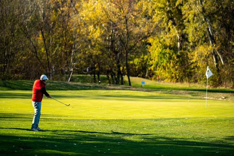 Голфър играе на Golf Club Ada в Белград, Сърбия – удар към грийна сред есенни дървета